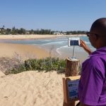 Dr Ernesto Macaringue taking the first photo “snap” from the CoastSnap station in Tofo beach (#coastsnaptofo)